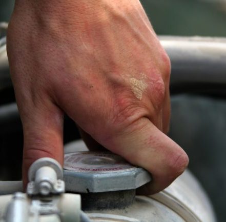 man checking truck radiator coolant level on a semi truck